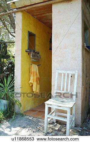Stock Image - Wooden chair at house entrance. Fotosearch