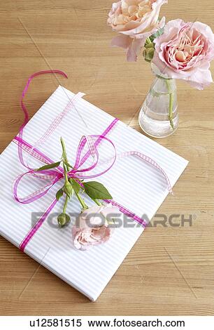 Stock Photography - Wrapped gift with rose blossoms. Fotosearch