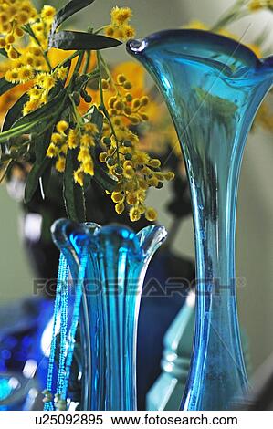 Yellow flowers in blue glass vase View Large Photo Image Stock Photography - Yellow flowers in blue glass vase. Fotosearch