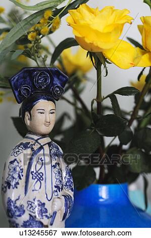 Stock Photo - Yellow roses and Asian figurine. Fotosearch