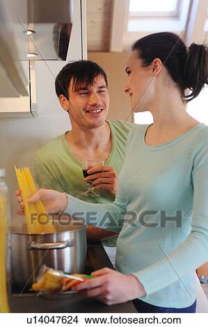 Young couple in kitchen cooking spaghetti and drinking red wine View Large Photo Image Picture - Young couple in kitchen cooking spaghetti and drinking red wine. Fotosearch
