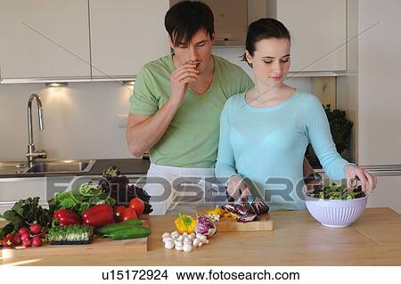 Young couple in kitchen preparing salad View Large Photo Image Picture - Young couple in kitchen preparing salad. Fotosearch