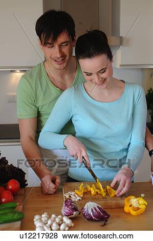 Young couple in kitchen preparing salad View Large Photo Image Stock Photo - Young couple in kitchen preparing salad. Fotosearch