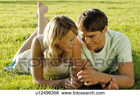 Stock Photo - Young couple lying in meadow. Fotosearch