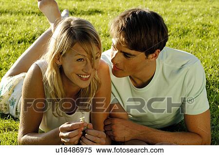 Young couple lying in meadow View Large Photo Image Stock Photography - Young couple lying in meadow. Fotosearch
