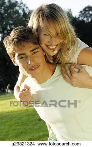 Picture - Young man carrying woman piggyback. Fotosearch