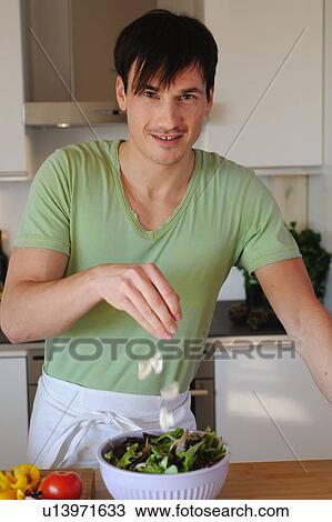 Young man in kitchen preparing salad View Large Photo Image Stock Image - Young man in kitchen preparing salad. Fotosearch