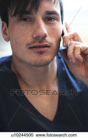 Stock Image - Young man using cell phone. Fotosearch