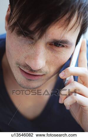 Young man using cell phone View Large Photo Image Stock Image - Young man using cell phone. Fotosearch