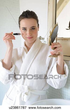 Young woman applying blush in bathroom View Large Photo Image Stock Photo - Young woman applying blush in bathroom. Fotosearch