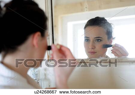 Young woman applying blush in bathroom View Large Photo Image Stock Photo - Young woman applying blush in bathroom. Fotosearch