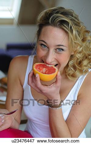 Stock Photo - Young woman biting into grapefruit. Fotosearch