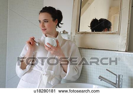 Young woman drinking coffee in bathroom View Large Photo Image Stock Image - Young woman drinking coffee in bathroom. Fotosearch