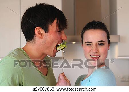 Young woman feeding man with salad View Large Photo Image Stock Photo - Young woman feeding man with salad. Fotosearch