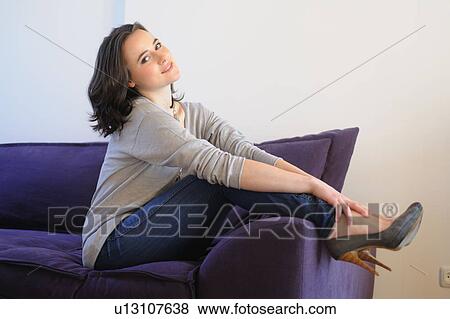 Young woman on sofa putting her feet up View Large Photo Image Stock Photo - Young woman on sofa putting her feet up. Fotosearch
