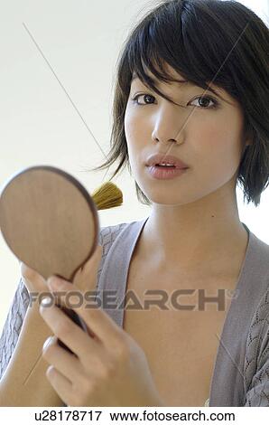 Stock Photo - Young woman putting on make-up. Fotosearch
