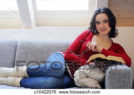 Young woman reading book on couch View Large Photo Image Stock Photograph - Young woman reading book on couch. Fotosearch