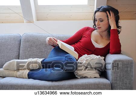 Young woman reading book on couch View Large Photo Image Stock Photograph - Young woman reading book on couch. Fotosearch