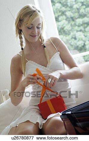 Stock Photo - Young woman wrapping gift. Fotosearch