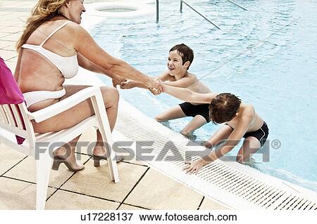 2 boys coaxing grandmother into pool View Large Photo Image Stock Photo - 2 boys coaxing grandmother into pool. Fotosearch