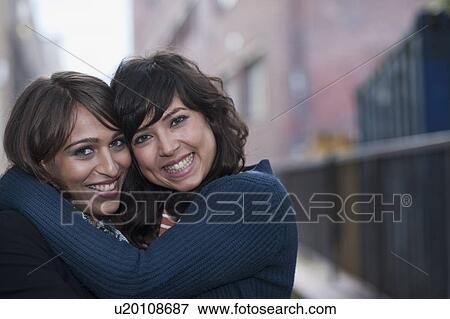 2 females hugging and posing to camera View Large Photo Image Stock Photo - 2 females hugging and posing to camera. Fotosearch