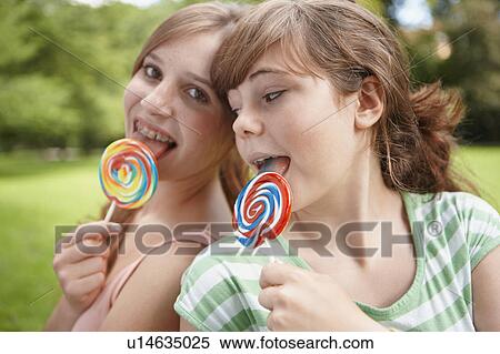2 girls eating lollipops together View Large Photo Image Stock Photography - 2 girls eating lollipops together. Fotosearch