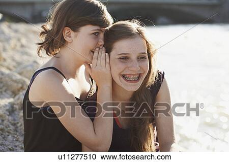 Stock Image - 2 girls having fun together in a park. Fotosearch
