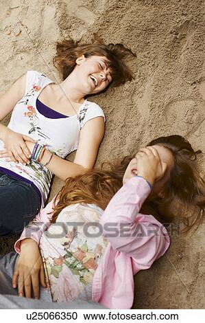 Stock Image - 2 girls having fun together in a park. Fotosearch
