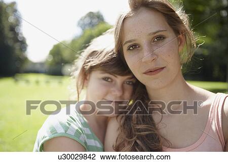 Stock Image - 2 girls having fun together in a park. Fotosearch
