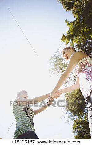 Stock Photo - 2 girls having fun together in a park. Fotosearch