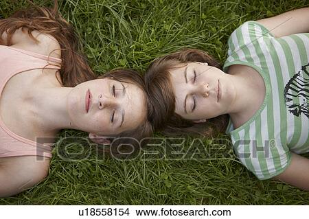 Picture - 2 girls relaxing together in a park. Fotosearch