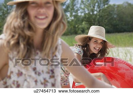 Stock Image - 2 pretty women having fun on a beach. Fotosearch