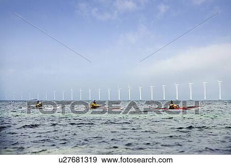 Stock Photo - 3 kayakers in front of mills. Fotosearch