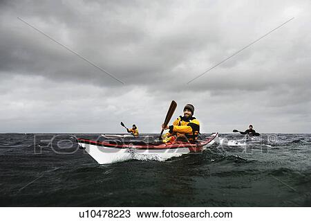 Stock Image - 3 kaykers on see. Fotosearch