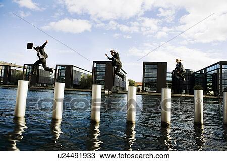 Stock Image - 3 people jumping poles. Fotosearch
