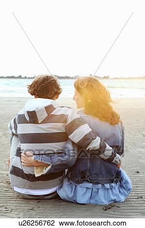 A couple watching the sunset at a beach View Large Photo Image Stock Image - A couple watching the sunset at a beach. Fotosearch