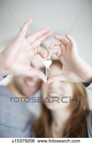 Stock Photograph - A happy couple holding a key. Fotosearch