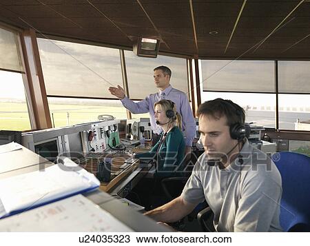 Stock Image - Air traffic controllers in tower. Fotosearch