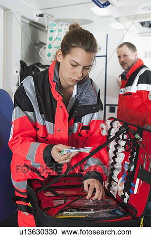 Stock Image - Ambulance woman in coach, preparing. Fotosearch