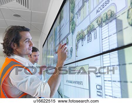 Stock Photography - Architects work with plans on screen. Fotosearch