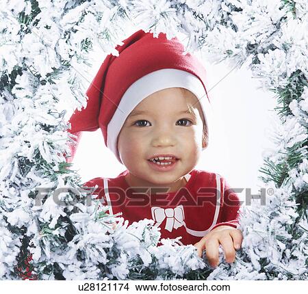 Baby girl looking through the snowy tree View Large Photo Image Picture - Baby girl looking through the snowy tree. Fotosearch