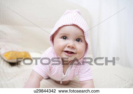 Stock Image - Baby on a bed. Fotosearch