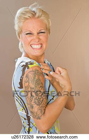 Beautiful girl showing tattoo on arm View Large Photo Image Stock Photo - Beautiful girl showing tattoo on arm. Fotosearch