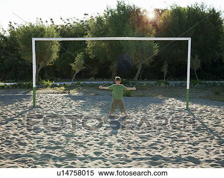 Boy (7-9) standing in soccer goal View Large Photo Image Stock Photography - Boy (7-9) standing in soccer goal. Fotosearch
