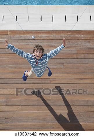 Boy (8-10) leaping into air, aerial view View Large Photo Image Stock Image - Boy (8-10) leaping into air, aerial view. Fotosearch