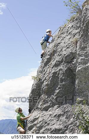 Boy and man climbing a mountain View Large Photo Image Stock Image - Boy and man climbing a mountain. Fotosearch