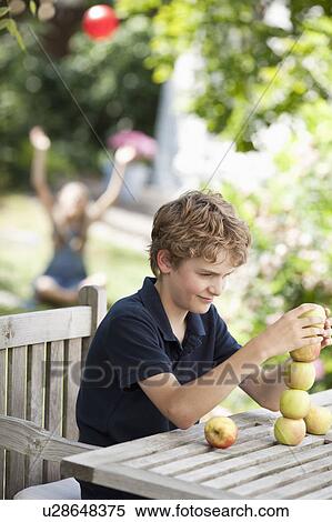 Boy building a tower out apples View Large Photo Image Stock Photography - Boy building a tower out apples. Fotosearch