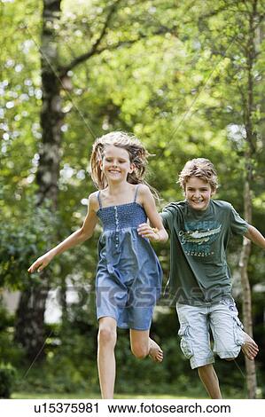 Boy chasing girl in garden View Large Photo Image Stock Image - Boy chasing girl in garden. Fotosearch