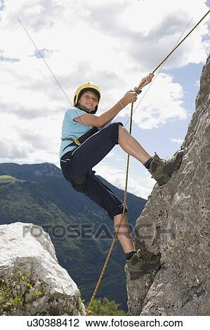 Boy climbing a rock with a rope View Large Photo Image Stock Image - Boy climbing a rock with a rope. Fotosearch
