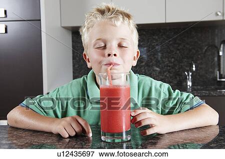 Stock Photo - Boy drinking fruit juice with straw. Fotosearch